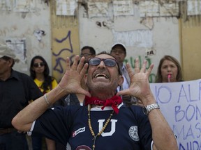 A protestor chants anti-government slogans at Congress, in Guatemala City, Thursday, Sept. 14, 2017. Several protests emerged against Guatemala's Congress after it approved legislation reducing the punishment for campaign-finance crimes Wednesday, two days after blocking prosecutors and a U.N. anti-corruption commission from investigating President Jimmy Morales for alleged irregularities during the election that brought him to office. (AP Photo/Moises Castillo)