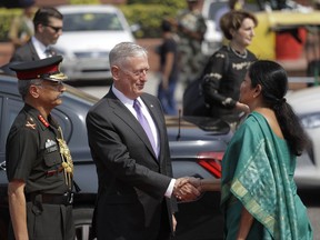 Indian Defense Minister Nirmala Sitharaman, right, welcomes U.S. Defense Secretary James Mattis, center, upon his arrival at the Defense Ministry office in New Delhi, India, Tuesday, Sept. 26, 2017. (AP Photo/Manish Swarup)