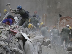 Rescue workers search for survivors at an apartment building located on the street corner of Amsterdam and Laredo, that collapsed during an earthquake in the Condesa neighborhood of Mexico City, Thursday, Sept. 21, 2017. Tuesday's magnitude 7.1 earthquake has stunned central Mexico, killing more than 200 people as buildings collapsed in plumes of dust. (AP Photo/Natacha Pisarenko)