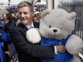 New Zealand Prime Minister Bill English embraces a National Party mascot while on the campaign trail in Cambridge, New Zealand, Friday, Sept. 22, 2017. English is fighting to keep his job when the nation votes in the general election on Saturday, Sept. 23. (Mark Mitchell/New Zealand Herald via AP)