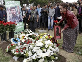 Former guerrillas of the Revolutionary Armed Forces of Colombia pay homage to slain rebel leader Jorge Briceno, known as Mono Jojoy, one of their most-prominent and despised military strategists, at his grave in a cemetery in southern Bogota, Colombia, Friday, Sept. 22, 2017. Briceno was killed by the Colombian Army on Sep. 22, 2010. (AP Photo/Ricardo Mazalan)