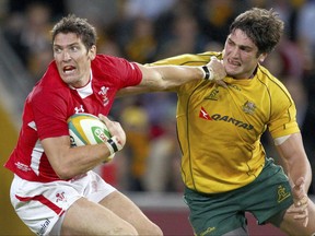 FILE - In this June 9, 2012 file photo Wales' James Hook, left, fends off Australia's Rob Simmons during their rugby union test match at Brisbane, Australia. Australia's coach, Michael Cheika, said on Thursday, Sept. 14, 2017, said Simmons would line up for his 75th test cap against Argentina in Canberra, Saturday. (AP Photo/Rick Rycroft, FILE)