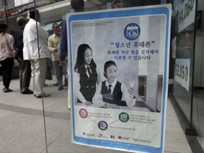 In this May 15, 2015 file photo, a promotional banner of mobile apps that block harmful contents, is posted on the door at a mobile store in Seoul, South Korea. The banner reads: "Young smartphone users, you must install apps that block harmful content." A South Korean child-monitoring smartphone app that was removed from the market in 2015 after it was found to be riddled with security holes has been reissued under a new name and puts children at risk, researchers said Monday, Sept. 11, 2017. (AP Photo/Lee Jin-man, File)