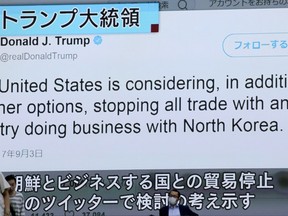 People walk by a TV news program showing Twitter of U.S. President Donald Trump while reporting North Korea's nuclear test, in Tokyo, Monday, Sept. 4, 2017. North Korea detonates its strongest ever nuclear test explosion and Trump takes to Twitter to criticize both North and South Korea, China and "any country doing business" with Pyongyang. But the tweet storm will be noticed in Asia as much for what's missing as for the tough words. (AP Photo/Shizuo Kambayashi)