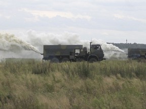 In this photo taken on Thursday, Sept. 14, 2017, Belarusian army specialists put a smoke screen during the war games at an undisclosed location in Belarus. Russia and Belarus began major war games Thursday, an operation involving thousands of troops, tanks and aircraft on NATO's eastern edge practicing how to hunt down and destroy armed spies, among other maneuvers. (Vayar Military Agency photo via AP)