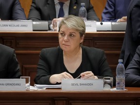 In this photo taken on Jan. 4, 2017, Romanian Deputy Premier Sevil Shhaideh attends a parliament session in Bucharest, Romania. Romanian anti-corruption prosecutors have initiated a criminal inquiry against a deputy prime minister on suspicion of abuse of office in a land transfer probe, saying in a statement Friday, Sept. 22, 2017, that in 2013 Sevil Shhaideh, at the time was a state secretary in the regional development ministry, allegedly aided the transfer of 324 hectares (800 acres) of land near the River Danube, to a local council county which then illegally leased it to a private company.(AP Photo/Vadim Ghirda)