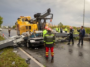 Emergency workers stand around a car that was destroyed by a traffic sign that fell due to heavy winds killing the driver in Timisoara, Romania, Sunday, Sept. 17, 2017, following a deadly storm that affects the west part of the country. Authorities say six people have died and at least 30 were injured during a violent storm in western Romania that produced winds of up to 100 kilometers (60 miles) an hour. (AP Photo/Cornel Putan)