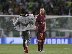 A fan runs towards Barcelona's Lionel Messi, interrupting a Champions League, Group D soccer match between Sporting CP and FC Barcelona at the Alvalade stadium in Lisbon, Wednesday Sept. 27, 2017. (AP Photo/Armando Franca)