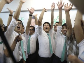 CORRECTS DATE - In this Sunday, Sept. 17, 2017 photo, a 26-year-old young pro-democracy activist Sulu Sou, center, celebrates with his supporters after he won a seat in voting Sunday for the city's semi-democratic legislature in Macau, China. Macau voters have elected Sulu Sou to the Chinese casino capital's legislature, as opposition lawmakers expanded their presence at the expense of candidates linked to the gambling industry. (Apple Daily via AP)