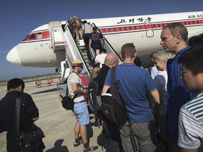 FILE - In this June 27, 2015, file photo, passengers board an Air Koryo plane bound for Beijing, at the Pyongyang International Airport in Pyongyang, North Korea.  A proclamation President Donald Trump signed Sunday, Sept. 24, 2017,  would suspend all immigrant and non-immigrant visas for North Koreans. But the measure is largely symbolic since most North Koreans in the U.S. are based at the United Nations and certain North Koreans are banned from traveling due to sanctions. (AP Photo/Wong Maye-E, File)