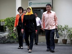 Halimah Yacob, center, leaves the Elections Department on Monday, Sept. 11, 2017, in Singapore. The Elections Department announced that Yacob, a former People's Action Party politician, will be declared Singapore's first female president on Wednesday, Sept. 13, as the two other potential candidates fell short of the qualification criteria. (Nuria Ling/ TODAY via AP)