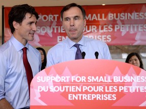 Finance Minister Bill Morneau speaks to members of the media as Prime Minister Justin Trudeau looks on at a press conference on tax reforms in Stouffville, Ont., on Monday, October 16, 2017.