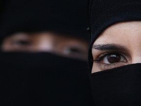 Two women wearing Islamic niqab veils stand outside the French Embassy during a demonstration on April 11, 2011 in London, England.