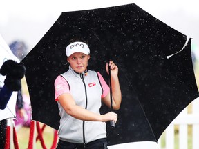 Brooke Henderson takes cover after play is called off because of lightning during Sunday's final round of the New Zealand Women's Open at Windross Farm on Oct. 1, 2017 in Auckland, New Zealand.