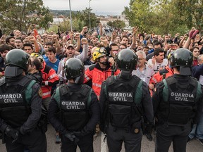 Police move back to their vans followed by members of the public after storming into polling station to confiscate ballot boxes and ballots where the President Carles Puigdemunt will vote later today on October 1, 2017 in Sant Julia de Ramis, Spain.