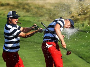 Charley Hoffman (left) sprays teammate Daniel Berger with champagne after the U.S. clinched the Presidents Cup in Jersey City, N.J., on Oct. 1.