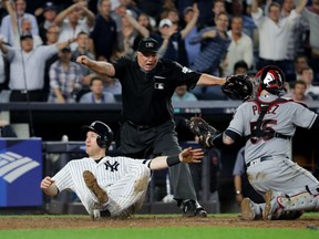Todd Frazier of the New York Yankees falls over after sliding save to home plate to score on Brett Gardner sacrifice fly against the Cleveland Indians during the fifth inning in Game Four of the American League Divisional Series at Yankee Stadium on Monday.