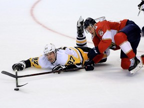 Pittsburgh Penguins captain Sidney Crosby (left) reaches for the puck against the Florida Panthers on Oct. 20.