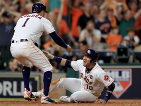 Yuli Gurriel and Carlos Correa of the Astros celebrate after they scored off of a double hit by Alex Bregman against David Robertson of the New York Yankees during the eighth inning in Game 6 of the American League Championship Series at Minute Maid Park in Houston on Friday night.