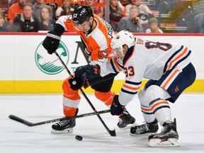 Edmonton Oilers defenceman Matt Benning (right) battles Philadelphia Flyers defenceman Shayne Gostisbehere for the puck on Oct. 21.