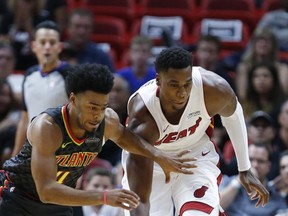 Atlanta Hawks guard Quinn Cook, left, and Miami Heat center Hassan Whiteside chase down the ball during the first half of an NBA preseason basketball game, Sunday, Oct. 1, 2017, in Miami. (AP Photo/Wilfredo Lee)
