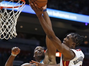 Miami Heat guard Josh Richardson (0) goes up for a shot against Charlotte Hornets center Dwight Howard (12) during the second half of an NBA preseason basketball game, Monday, Oct. 9, 2017, in Miami. The Heat defeated the Hornets 109-106. (AP Photo/Wilfredo Lee)