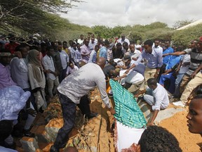 Somalis bury a body of a victim who died in Saturday's truck blast, in Mogadishu's Medina hospital graveyard in Mogadishu, Somalia, Tuesday, Oct, 17, 2017.  A United States military plane has landed in Somalia's capital with medical and humanitarian aid supplies after Saturday's massive truck bombing killed more than 300 people. (AP Photo/Farah Abdi Warsameh)