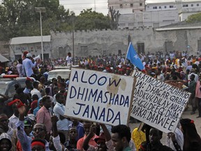 Protesters march as they carry placards reading "Out Al Shabab", left, and "Oh God, have mercy on the dead" near the scene of Saturday's massive truck bomb attack in Mogadishu, Somalia, Wednesday, Oct. 18, 2017. Thousands of people took to the streets of Somalia's capital Wednesday in a show of defiance after the country's deadliest attack, as two people were arrested in connection with Saturday's massive truck bombing that killed more than 300. (AP Photo/Farah Abdi Warsameh)