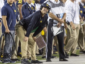 Michigan head coach Jim Harbaugh looks at the scoreboard along the sideline in the first quarter of an NCAA college football game against Michigan State in Ann Arbor, Mich., Saturday, Oct. 7, 2017. (AP Photo/Tony Ding)