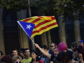 A pro independence supporter holds up an ''estelada'' or Catalan pro independence flag during a rally in support of the Catalonia's secession from Spain, in Pamplona, northern Spain, Thursday, Oct. 12, 2017. Spain's celebrates its national day amid one of the country's biggest crises ever as its powerful northeastern region of Catalonia threatens independence.(AP Photo/Alvaro Barrientos)