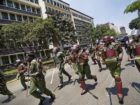 Kenyan riot police firing tear gas charge towards a small group of opposition supporters protesting over the upcoming elections in downtown Nairobi, Kenya, Monday, Oct. 16, 2017. Two international human rights groups said Monday that Kenya's police in August attacked opposition supporters killing dozens and injuring scores following demonstrations protesting President Uhuru Kenyatta's subsequently annulled re-election. (AP Photo/Ben Curtis)