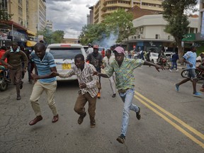 Supporters of opposition leader Raila Odinga flee from police firing tear gas as they attempt to demonstrate in downtown Nairobi, Kenya Tuesday, Oct. 24, 2017. Kenyan police have fired tear gas and warning shots to disperse small groups of opposition protesters ahead of a presidential election on Thursday that opposition leader Raila Odinga plans to boycott. (AP Photo/Ben Curtis)