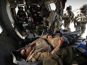 A Canadian soldier is treated by a U.S. military medic in southern Afghanistan on March 18, 2011.