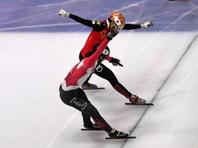 Canada's Samuel Girard (bottom) edges China's Han Tianyu at the finish line for men's 5,000-metre gold at a World Cup short track event in Budapest on Oct. 1.