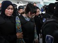 Vietnamese defendant Doan Thi Huong (C) is escorted by police personnel towards the low-cost carrier Kuala Lumpur International Airport 2 (KLIA2) in Sepang during a visit to the scene of the murder as part of the Shah Alam High Court trial process on October 24, 2017, for her alleged role in the assassination of Kim Jong-Nam.