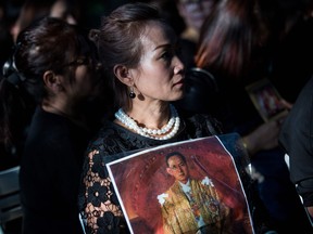 A mourner holds a picture of the late Thai King Bhumibol Adulyadej at a memorial service at the Wat Buddha Dhamaram in the Yuen Long district of Hong Kong on October 26, 2017.