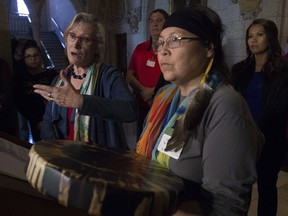 Surrounded by Chief Marcia Brown Martel and Sixties Scoop survivors, Crown-Indigenous Relations and Rorthern Affairs Minister Carolyn Bennett responds to a question during a news conference on Parliament Hill, in Ottawa on Friday, October 6, 2017. Bennett announced a compensation package for indigenous victims of the sixties scoop. THE CANADIAN PRESS/Adrian Wyld