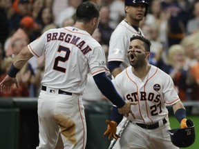 Jose Altuve is congratulated by Astros teammate Alex Bregman after hitting a home run during the fifth inning of Game 7 the American League Championship Series against the New York Yankees on Saturday night in Houston.