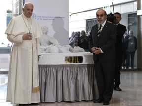 Pope Francis, left, and FAO Director-General Jose Graziano Da Silva, stands next to a marble statue representing the tragedy of migration donated by the pontiff during his visit to the United Nations Food and Agriculture Organization (FAO) on the occasion of the World Food Day, Monday, Oct. 16, 2017. The statue commemorates Aylan Kurdi, the 3-year old refugee boy drowned on Sept. 2015 while crossing the Mediterranean Sea. (AP PhotoAndrew Medichini)