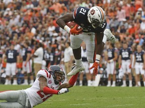 Mississippi defensive back Javien Hamilton (21) trips up Auburn running back Kerryon Johnson (21) during the first half of an NCAA college football game in Auburn, Ala., Saturday, Oct. 7, 2017. (AP Photo/Thomas Graning)