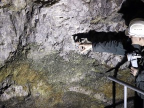 FILE  - In this file photo taken on Wednesday, March 22, 2017, Otto Janout, a prospector and one of the four founders of Geomet company, points at ore containing lithium inside a former mine located at the border with Germany near the village of Cinovec, Czech Republic. Australia's company European Metals Holdings (EMH) that has signed an agreement of understanding with the Czech government about a possible mining of lithium in the Czech Republic. Recent explorations have found the biggest deposit of lithium in Europe in northwestern Czech Republic. (AP Photo/Petr David Josek, File)