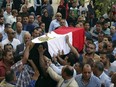 People carry the coffin, covered with the an Egyptian flag, of police captain Ahmed Fayez who was killed in a gun battle in al-Wahat al-Bahriya area in Giza province, about 135 kilometers (84 miles) southwest of Cairo, during his funeral at Al-Hosary mosque, in Cairo, Egypt, Saturday, Oct. 21, 2017.