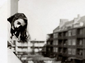Anne Frank leans over the balcony of her apartment in Amsterdam in May 1941. The photograph was made by her father, Otto Frank.