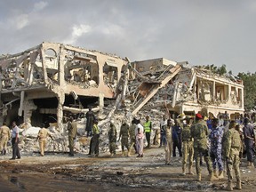 Somali security forces and others gather and search for bodies near destroyed buildings at the scene of Saturday's blast, in Mogadishu, Somalia Sunday, Oct. 15, 2017.
