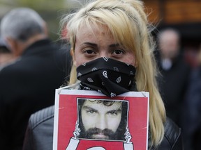 A protester holds a photo of Santiago Maldonado during a demonstration at Plaza de Mayo in Buenos Aires, Argentina, Sunday, Oct. 1, 2017