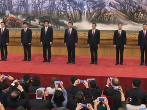 In this Wednesday, Oct. 25, 2017, file photo, new members of the Politburo Standing Committee, from left, Han Zheng, Wang Huning, Li Zhanshu, Xi Jinping, Li Keqiang, Wang Yang, Zhao Leji stand together at Beijing's Great Hall of the People. The seven-member Standing Committee, the inner circle of Chinese political power, was paraded in front of assembled media on the first day following the end of the 19th Communist Party Congress. (AP Photo/Ng Han Guan, File)