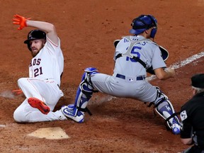 Pinch runner Derek Fisher of the Houston Astros scores the game-winning run in the bottom of the 10th inning to give the Astros a 3-2 lead over the Los Angeles Dodgers in the World Series by virtue of a wild and crazy 13-12 win in Houston on Sunday night. Waiting for the throw is Dodgers' catcher Austin Barnes. Game 6 is Tuesday in Los Angeles.