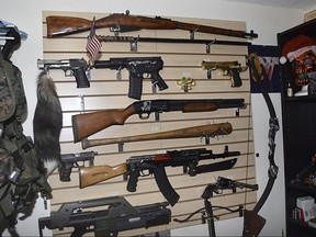 In this undated photo released by the Pinellas County Sheriff's Office, a weapons cache is shown in the home of Randall Drake. Sheriff's deputies conducting a child porn raid on the home found an arsenal of guns and explosives and a homemade silencer, along with a note promising "bloody revenge." Pinellas County Sheriff Bob Gualtieri told reporters Thursday night, Oct. 19, 2017, deputies also found aerial images of two schools and a water plant in nearby Tampa. There was also a note that deputies believe Drake wrote, promising he'll have his "bloody revenge" and "the world will burn burn."  (Pinellas County Sheriff's Office via AP)