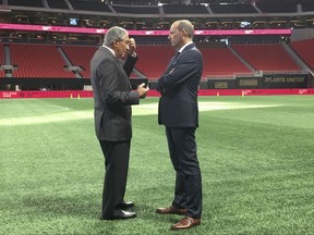 In this Oct. 23, 2017 photo, Atlanta United owner Arthur Blank, left, and Major League Soccer Commissioner Don Garber talk on the field at Mercedes-Benz Stadium in Atlanta, after Atlanta was chosen to host the 2018 MLS All-Star Game. Welcome to Atlanta, soccer's newest hotbed, which amazingly enough has sprouted up in a city known for its fickle sports fans and plenty of heartbreak from its teams.   (AP Photo/Paul Newberry)