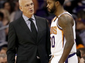 Phoenix Suns head coach Jay Triano speaks with Phoenix Suns guard Troy Daniels (30) during the first half of an NBA basketball game against the Sacramento Kings, Monday, Oct. 23, 2017, in Phoenix. It was Triano's first game as the Suns' head coach. (AP Photo/Matt York)